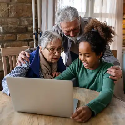 little girl with grandparents using computer